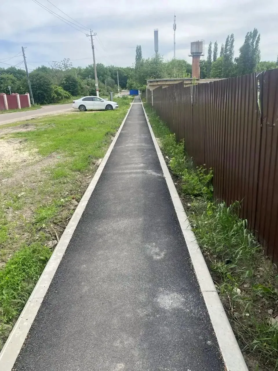 Новый асфальтовый тротуар с бордюром
